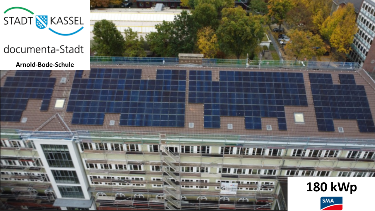 Solaranlage mit vielen dunkelblauen Modulen auf einem Schuldach in Kassel
