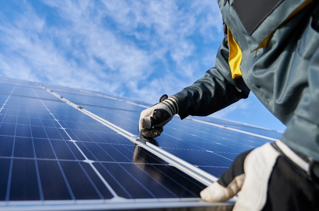 Ein Arbeiter repariert ein Photovoltaik-Solarmodul.