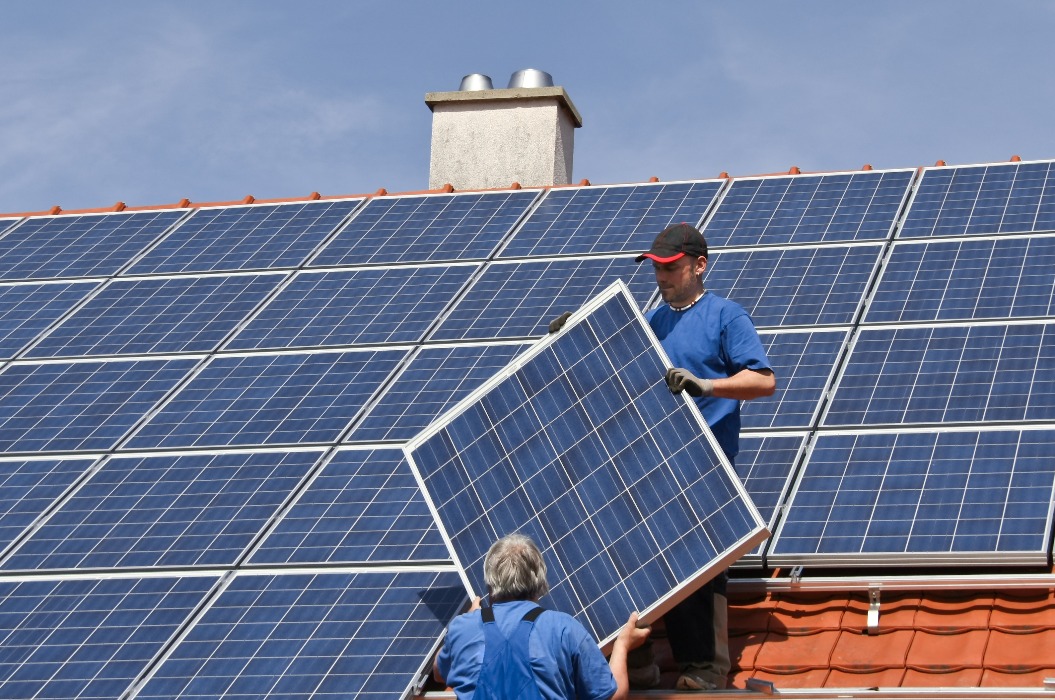 Zwei Arbeiter montieren Solaranlagen